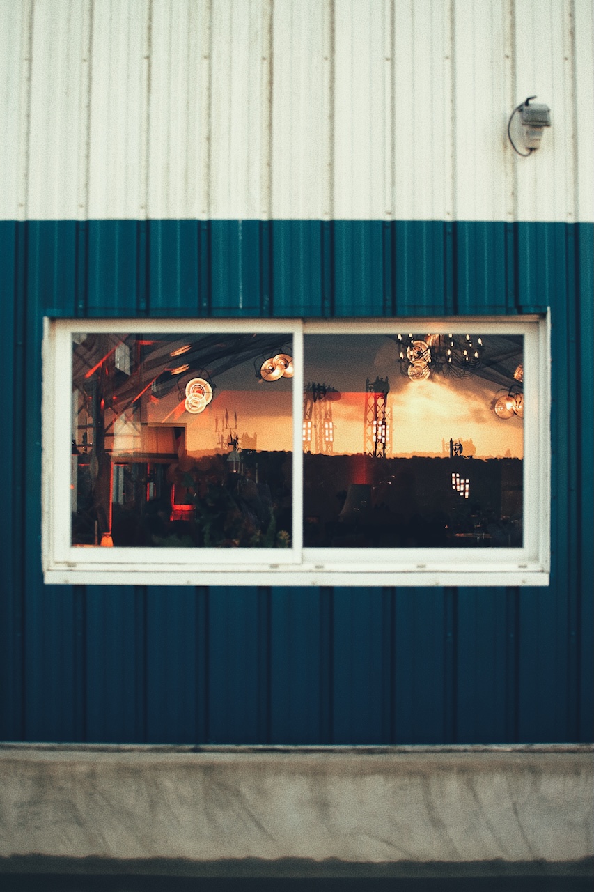Reflet de la scène et des lustres dans la fenêtre d'une cabane bleue