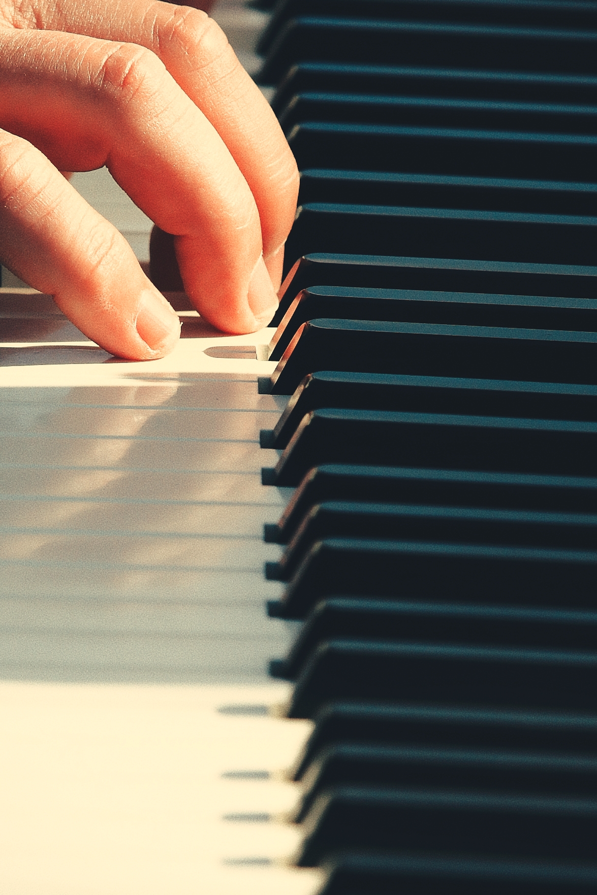 Mains sur un clavier de piano, lumière chaude