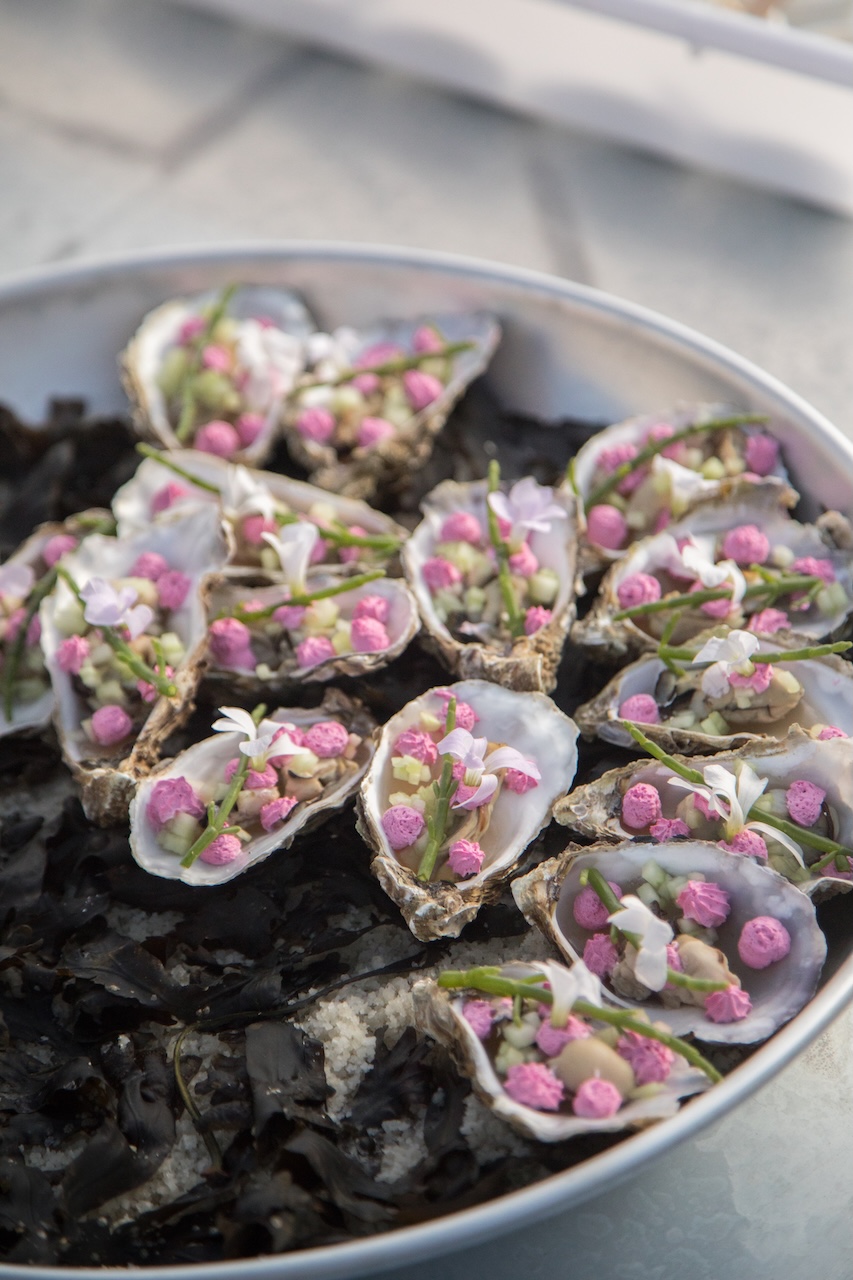Plateau d'huîtres dressées avec fleurs comestibles et perles roses