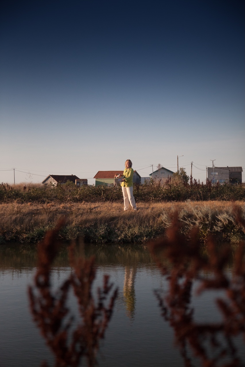 Charlotte, productrice, dans un paysage de marais au coucher du soleil