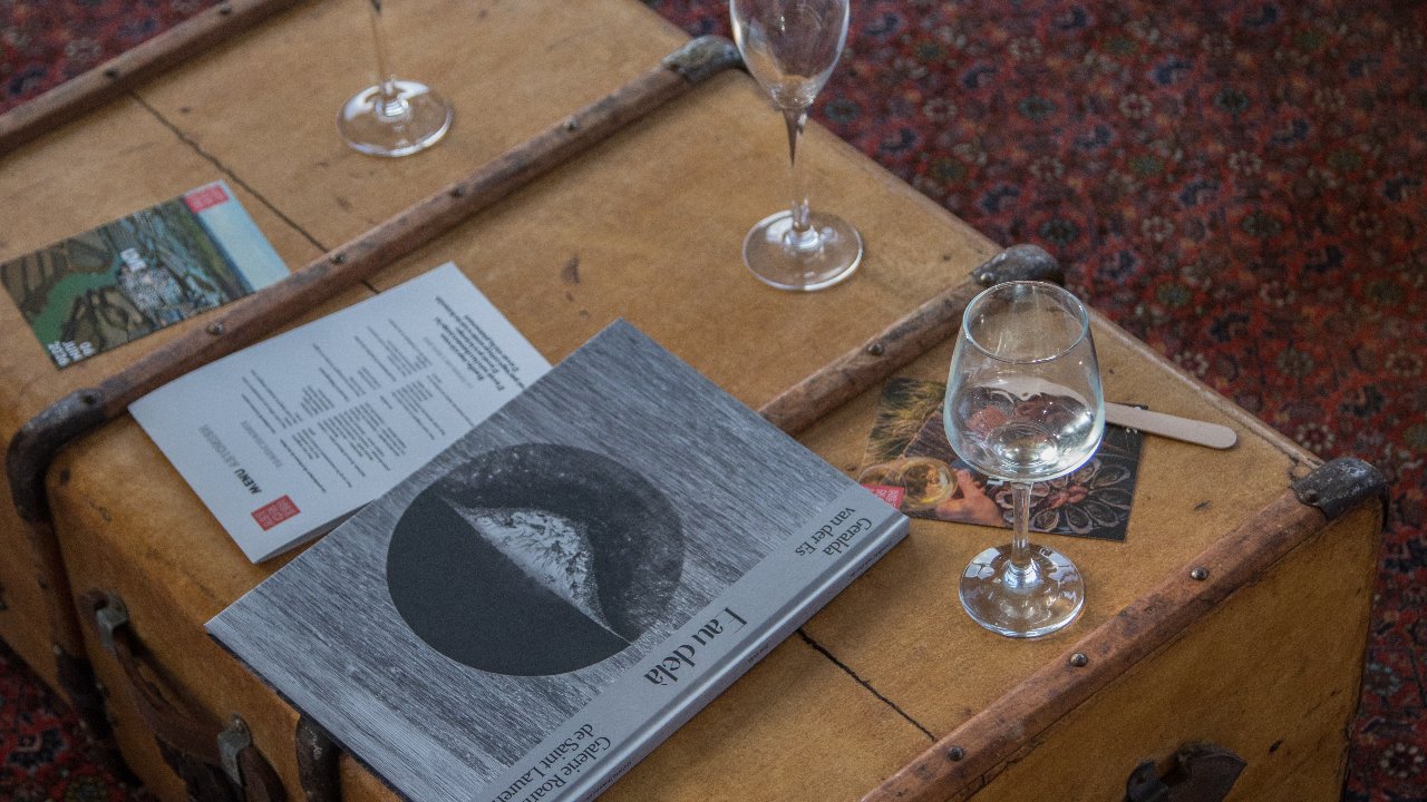 Malle en bois vintage avec verres à vin et livret sur un tapis d'Orient